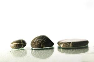 pietre zen bagnate isolate con spruzzi d'acqua foto