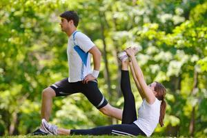 coppia che fa esercizio di stretching dopo aver fatto jogging foto