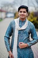l'uomo indiano indossa abiti tradizionali con sciarpa bianca posata all'aperto. foto