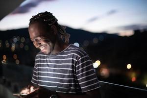 giovane afro in strada di notte tramite telefono foto