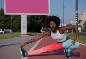 ritratto di giovane donna afroamericana sportiva che si estende all'aperto foto