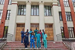 gruppo di studenti di medicina africani posati all'aperto contro la porta dell'università. foto