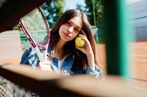 giovane ragazza sportiva con racchetta da tennis sul campo da tennis. foto