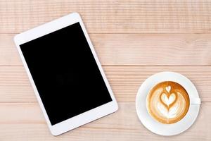 caffè latte e telefono cellulare o tablet con sfondo di legno mockup schermo vuoto foto