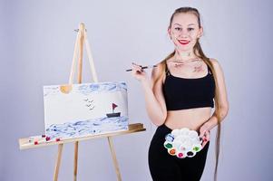 bella donna artista pittore con spazzole e tela a olio in posa in studio isolato su bianco. foto