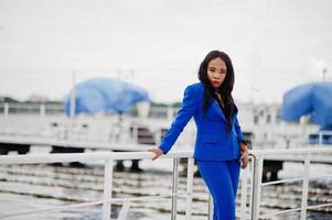 successo donna d'affari afroamericana al vestito blu con il telefono cellulare. foto