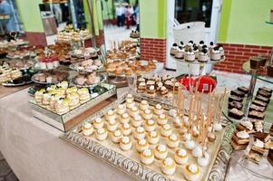 bellissimo matrimonio candy bar con dolci, frutta e cibo. tavolo per banchetti di nozze foto