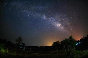 galassia della via lattea e silhouette di albero con nuvola. fotografia a lunga esposizione. con grano foto