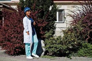 medico afroamericano femmina con stetoscopio poste all'aperto. foto