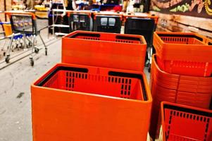 cestini della spesa in plastica arancione sul supermercato. foto