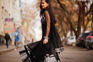 bella ragazza indiana in abito saree nero poste all'aperto in autunno street. foto