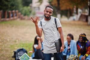 gruppo di cinque studenti universitari africani che trascorrono del tempo insieme nel campus nel cortile dell'università. amici afro neri che studiano. tema dell'educazione. foto