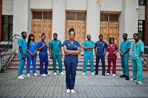 gruppo di studenti di medicina africani posati all'aperto contro la porta dell'università. foto