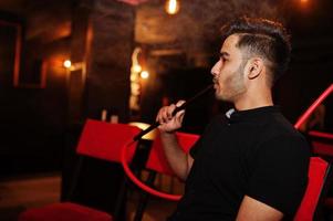 l'uomo asiatico fuma narghilè e riposa al lounge bar. foto