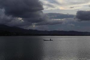 sagoma di pescatore sulla sua barca foto