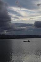 pescatore sulla sua barca al tramonto. barca di pescatori al tramonto foto