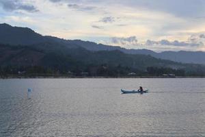 sagoma di pescatore sulla sua barca foto