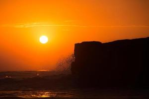 tramonto sopra il tempio indù pura tanah lot, bali, indonesia foto