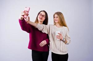 due ragazze in abiti viola che si fanno selfie in studio. foto