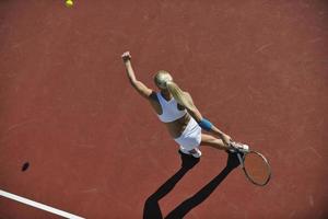 giovane donna giocare a tennis all'aperto foto