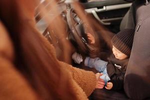 giovane madre e bambino in auto. concetto di guida di sicurezza. foto