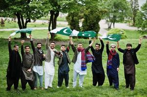 gruppo di pakistani che indossano abiti tradizionali salwar kameez o kurta con bandiere pakistane. foto