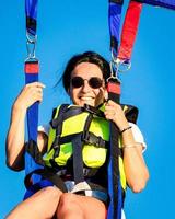 ragazza sorriso in parasail parashute a mezz'aria. concetto di sicurezza ed esperienza di parapendio foto