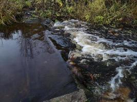 forte corrente su un piccolo fiume. rapide sull'acqua foto