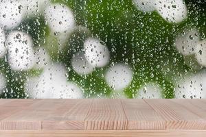 piano del tavolo in legno marrone su sfondo bokeh astratto goccia d'acqua - può essere utilizzato per il montaggio o visualizzare i tuoi prodotti foto