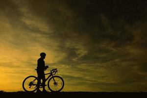 silhouette di bell'uomo in bicicletta sul tramonto, concetto di uomo sportivo foto