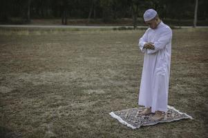 preghiera dell'uomo islam asiatico, preghiera dei giovani musulmani, concetto di festival del ramadan foto