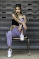Ritratto di ragazza hipster su sfondo muro di mattoni, bella donna asiatica posa per scattare una foto, stile kawaii foto