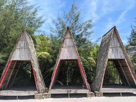 tre cabine sulla spiaggia ben disposte con bellissimi cipressi e cielo azzurro. foto