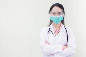 donna asiatica medico in camice bianco indossa maschera medica e visiera foto