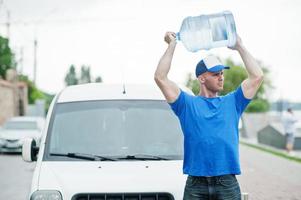 fattorino davanti al furgone che consegna bottiglie d'acqua. foto