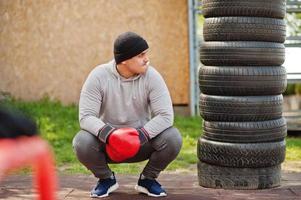 uomo pugile arabo in cappello che si allena per una dura lotta in palestra all'aperto. foto