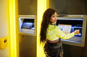 donna afroamericana che preleva denaro da un bancomat, concetto di bancomat. foto