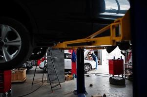 tema riparazione e manutenzione auto. meccanico in uniforme che lavora in servizio auto. foto