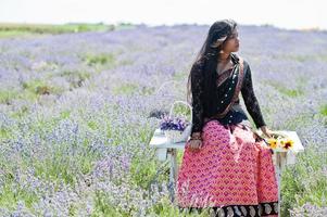 bella ragazza indiana indossa un abito tradizionale saree india nel campo di lavanda viola. foto