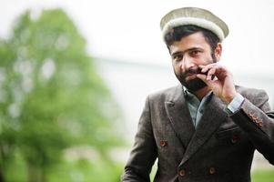 barba uomo afgano indossa cappello e giacca pakol. foto