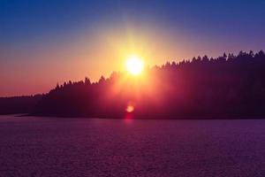 idilliaco tramonto colorato su un lago foto