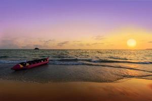 banana boat sulla spiaggia al tramonto foto