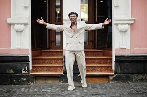 elegante uomo afro in abito beige vecchia scuola. giovane maschio africano alla moda in giacca casual sul torso nudo. foto