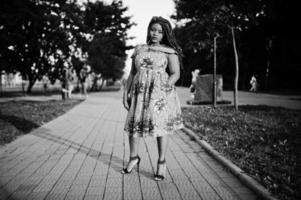 carina ragazza afroamericana di piccola altezza con i dreadlocks, indossa un abito giallo colorato, in posa al tramonto. bianco e nero. foto