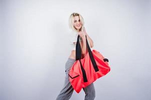 bionda ragazza sportiva con grande borsa sportiva poste in studio su sfondo bianco. foto