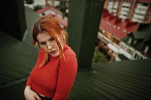 ritratto di moda di ragazza sexy dai capelli rossi sul tetto. modello attraente seduzione donna. foto