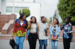 gruppo di cinque studenti universitari africani che trascorrono del tempo insieme nel campus nel cortile dell'università. amici afro neri che studiano. tema dell'educazione.