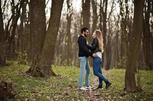 storia d'amore di una bella coppia multirazziale nella foresta primaverile. foto