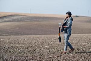 agronomo agricoltore del sud asiatico con pala che ispeziona il suolo nero. concetto di produzione agricola. foto