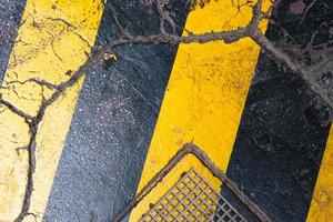 strisce gialle colorate sull'asfalto incrinato, motivo e trama, sfondo colorato, superficie strutturata foto